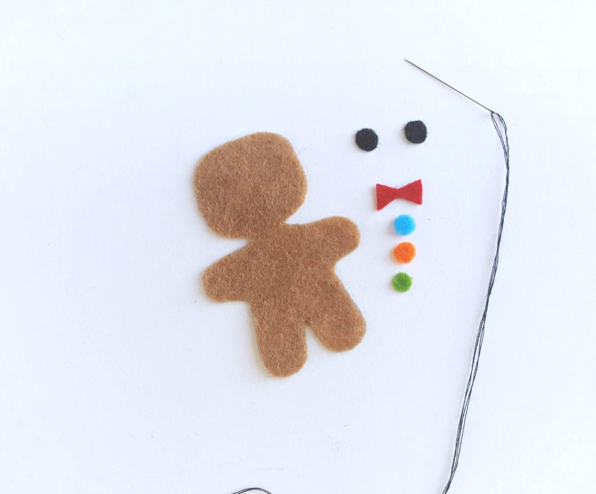 One brown felt cutout of a gingerbread man with eyes, bowtie, and gumdrop buttons.