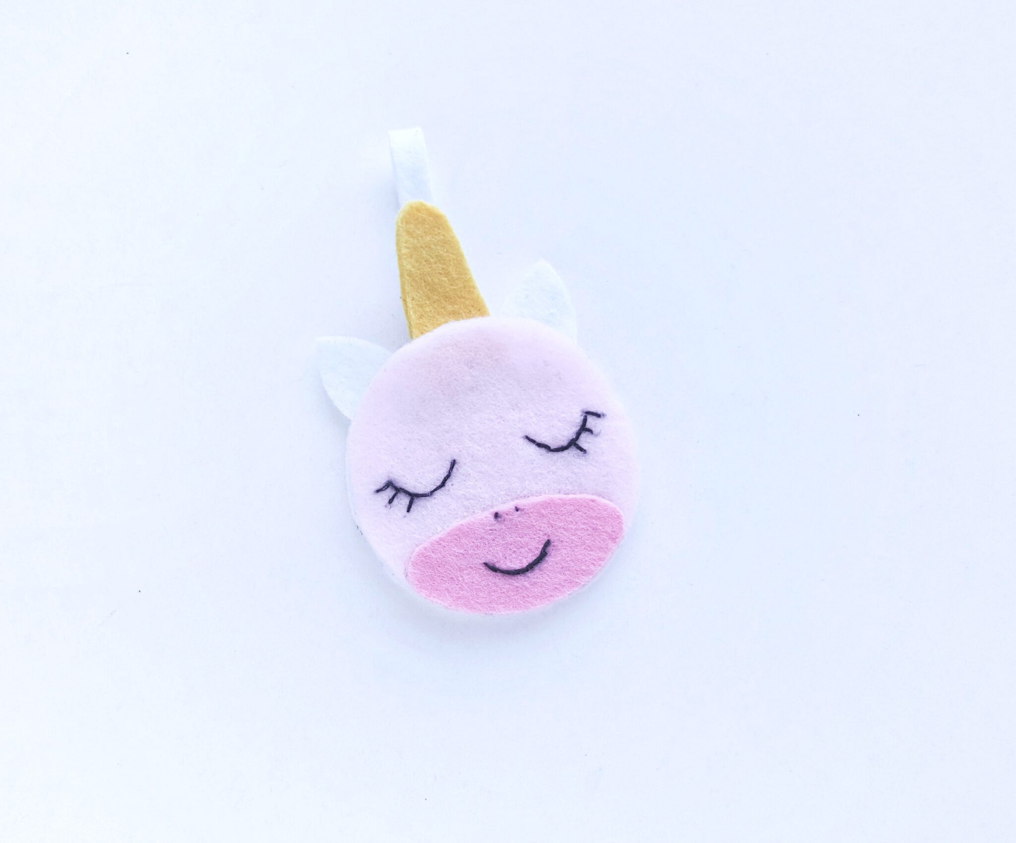 The unicorn face is placed on top of the other half (white head with horn) to be sewn together. 