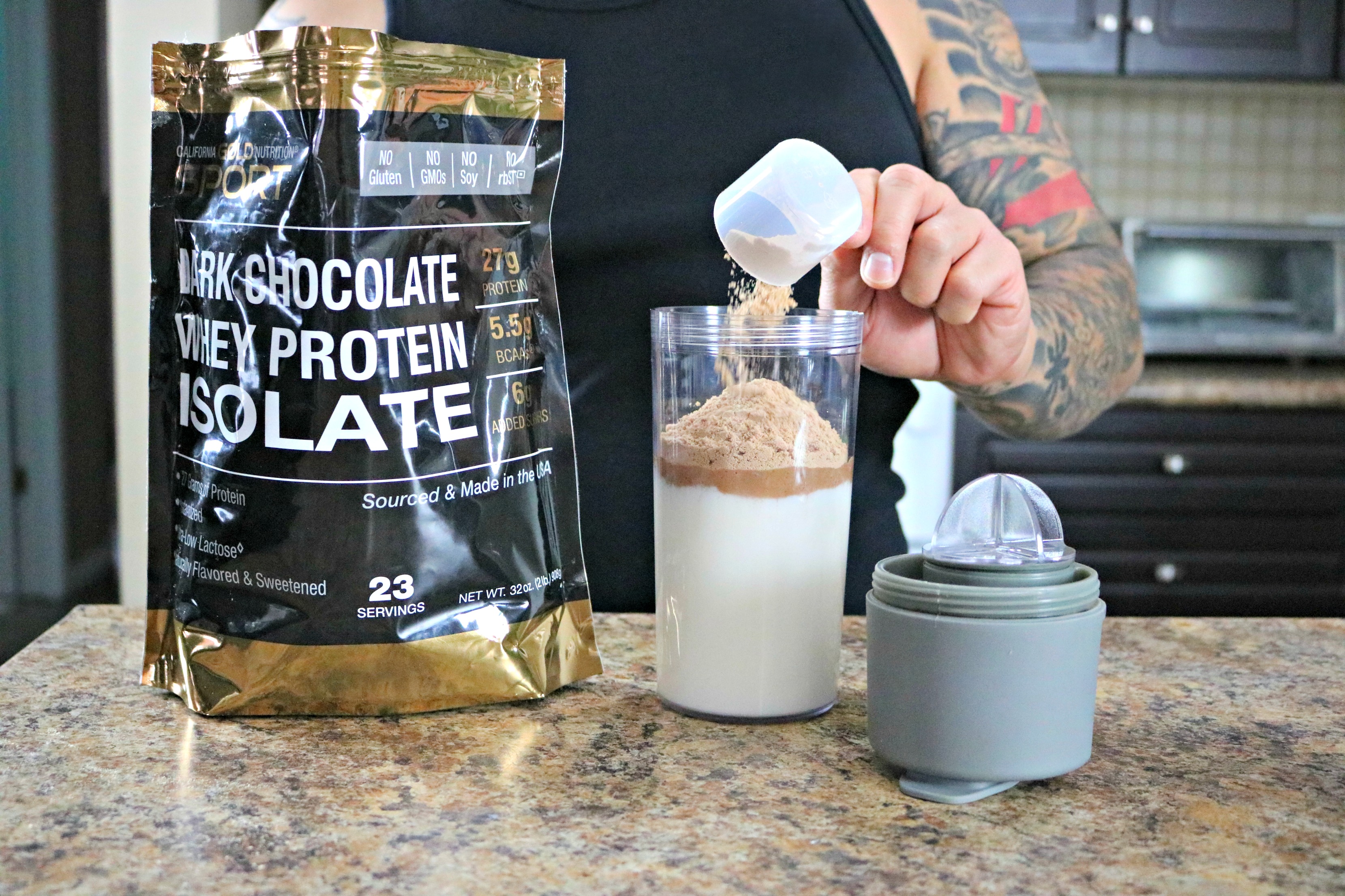 Dark Chocolate Whey Protein Isolate being poured into shaker bottle.