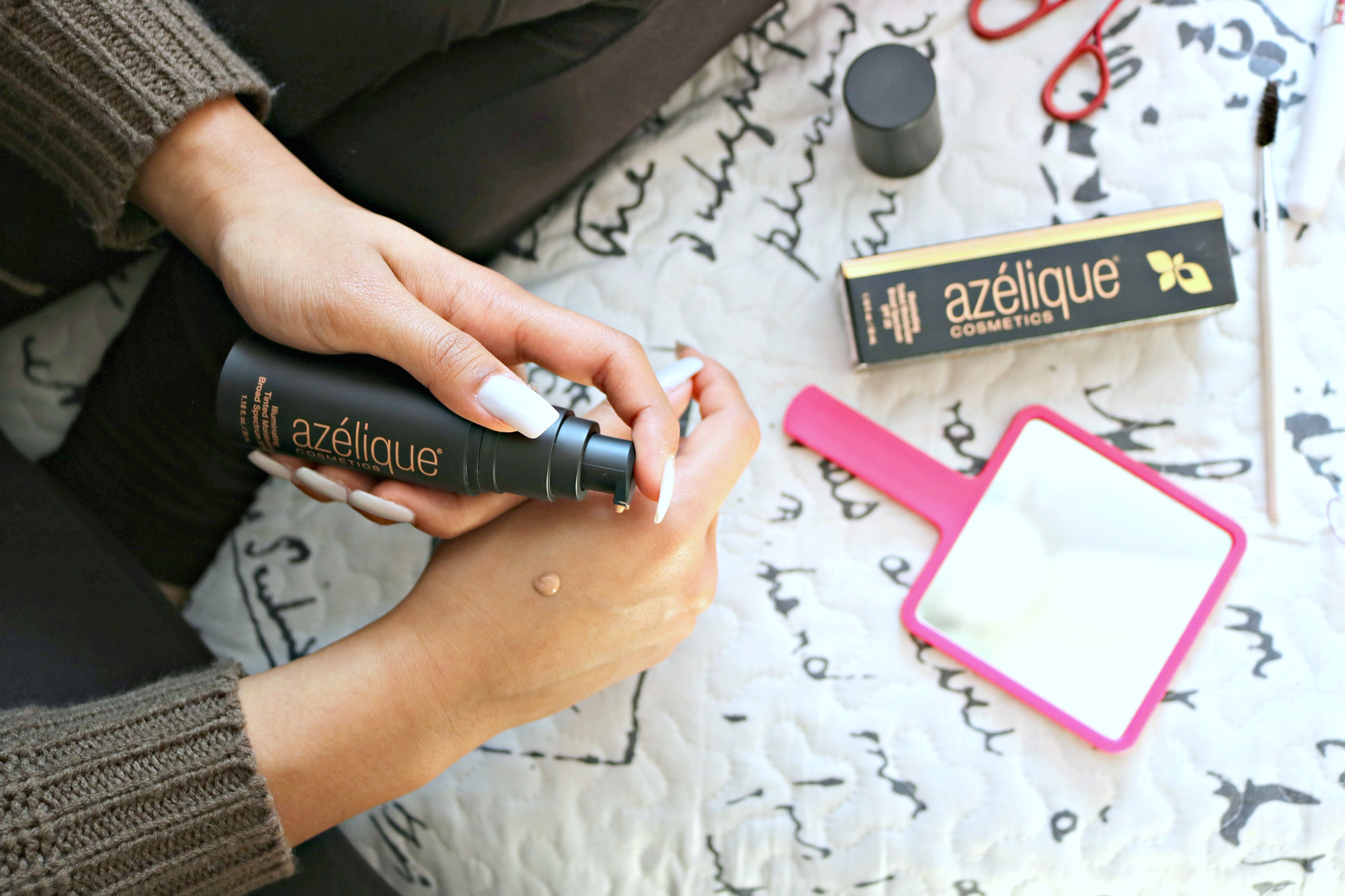 azelique tinted moisturizer being pumped onto a young woman's hand.