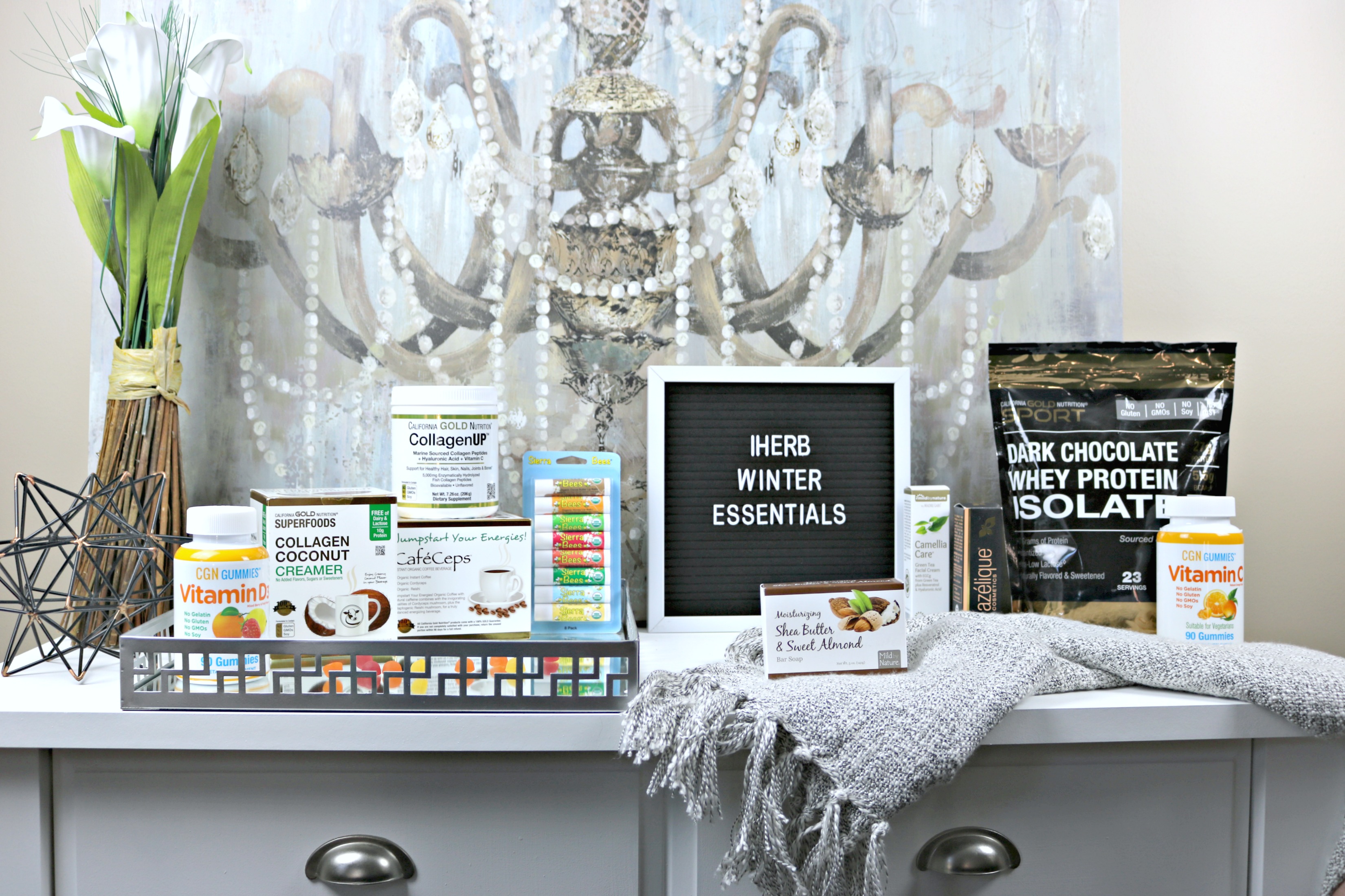 iHerb Winter Essentials on a buffet table and tray: Vitamins, coffee, creamer, vitamins, beauty products and more.