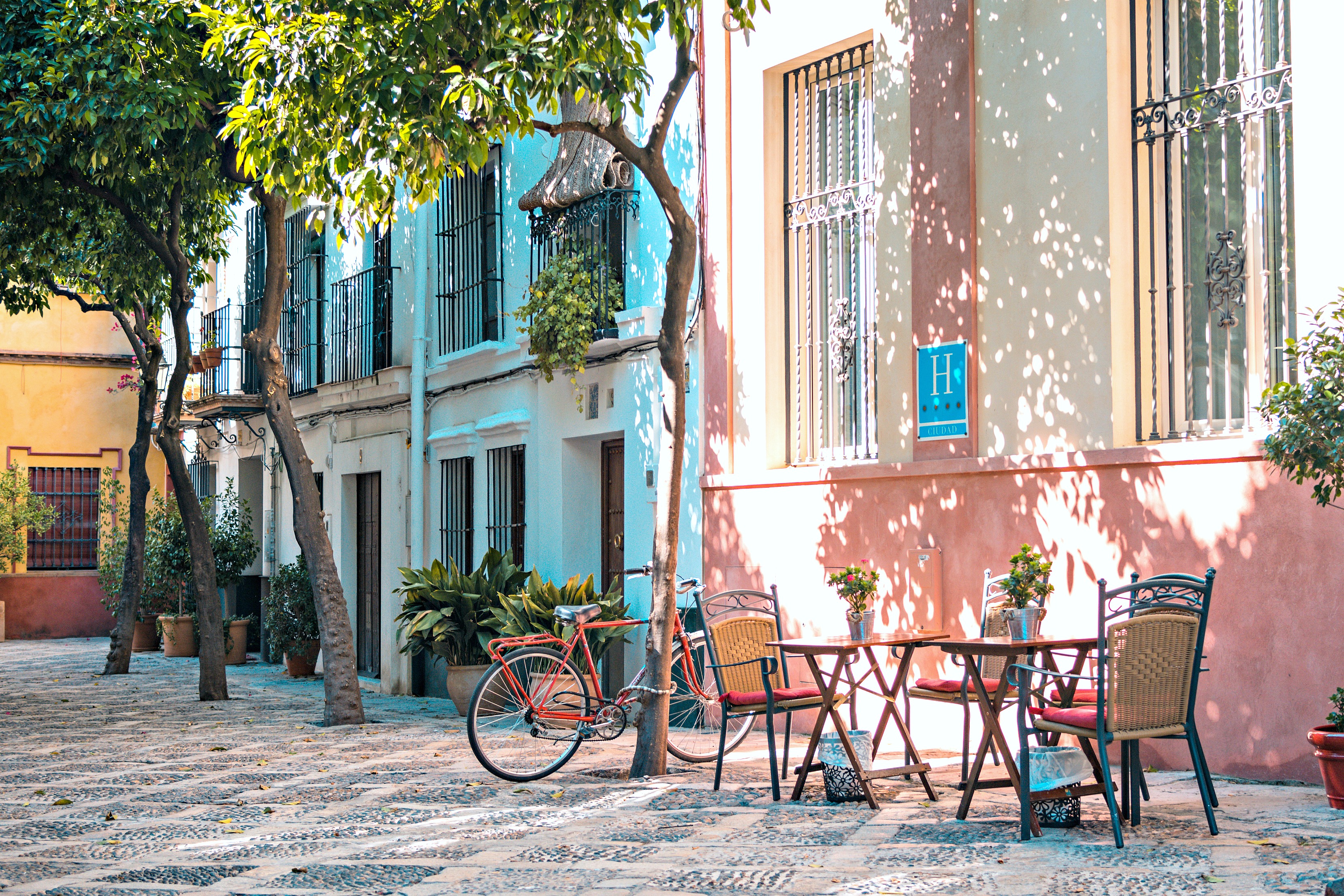 A little cafe in Barcelona with a bike parked beside.