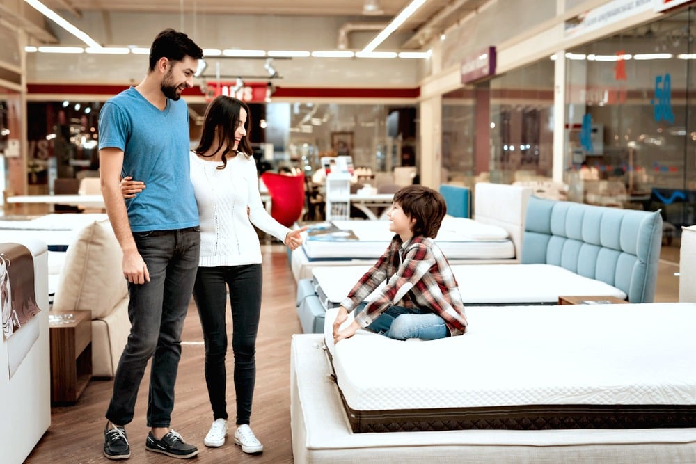 A couple with a young boy browse for new furniture. 