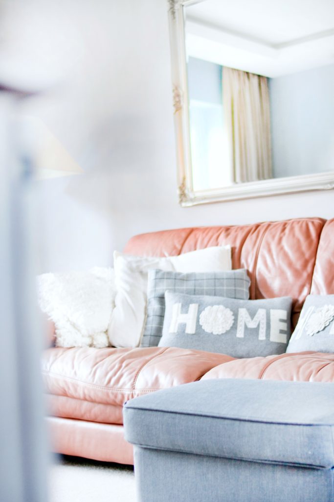 Couch with decorative pillows, one says 'Home'.