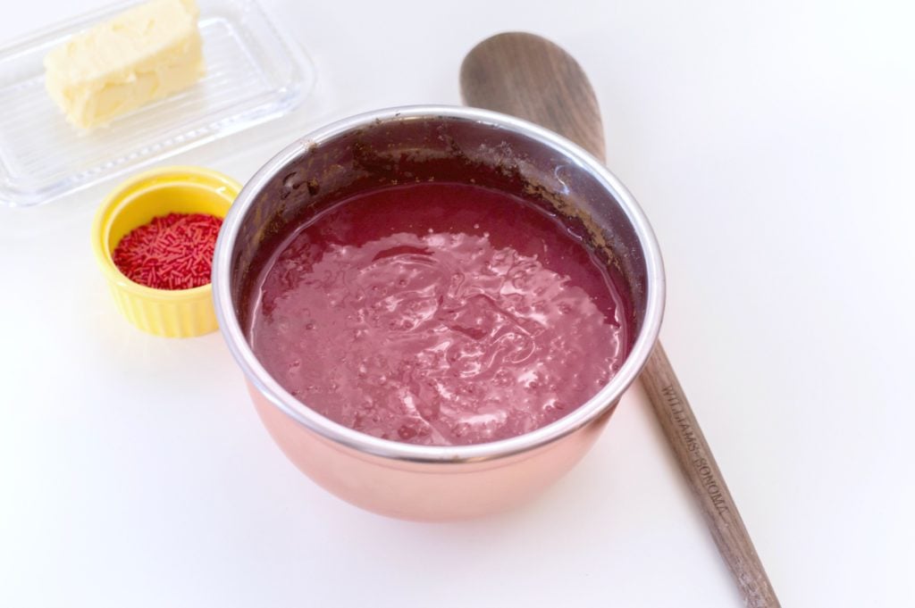 Red velvet is my favourite. It's even better when it's bite-sized, coated in candy and topped with sprinkles.Try these easy red velvet truffles! #redvelvet #desserts #truffles Red velvet cake mix in rose gold mixing bowl.