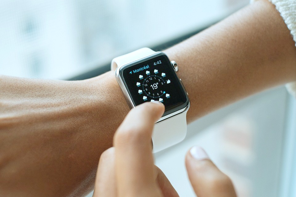 Woman touching her Apple smart watch.