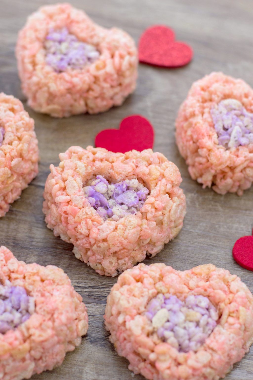 The finished Valentine's Day Rice Krispies treats on a wooden background with felt hearts to decorate.
