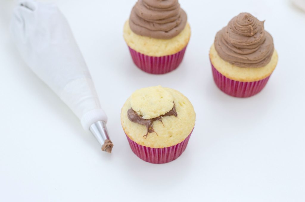 Cupcake is shown with top placed on top of Nutella filling. 