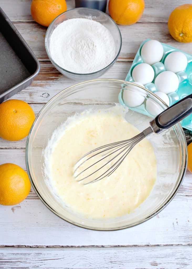 Eggs, sugar, and other ingredients mixed with whisk in bowl. 