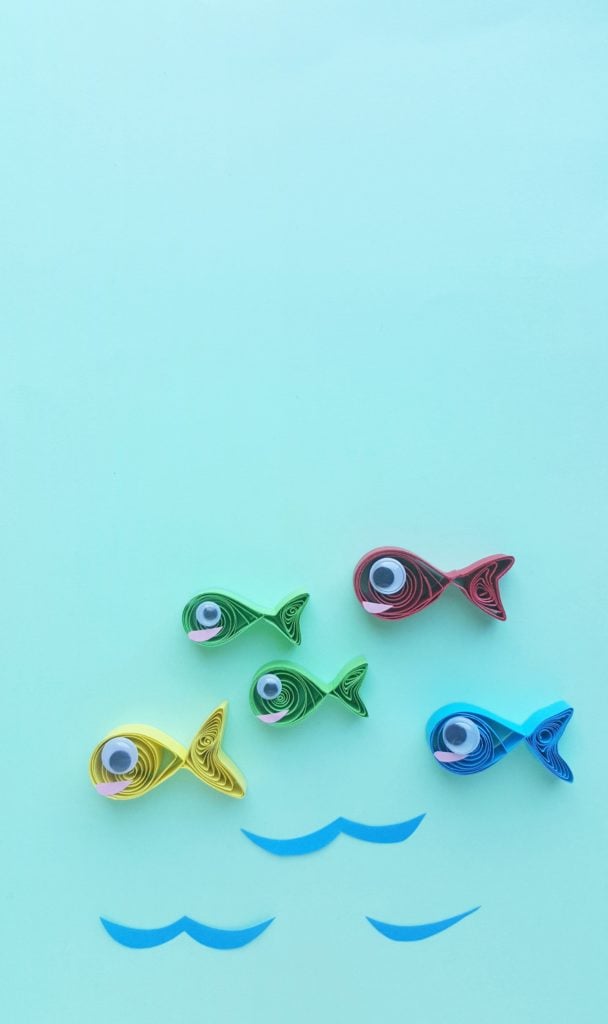 One fish, two fish, red fish, blue fish in quilled paper form. Blue construction paper waves against a blue background.