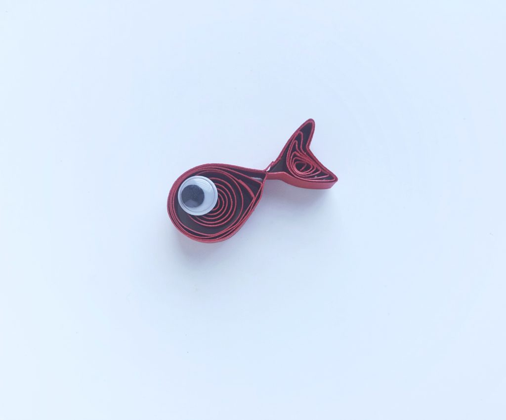 A shape of a fish has now taken form and a googly eye added to fish.