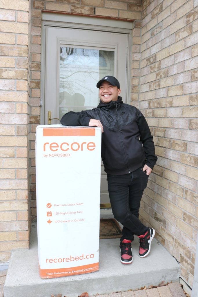 Darasak smiling and standing next to the Recore by Novosbed mattress delivery.