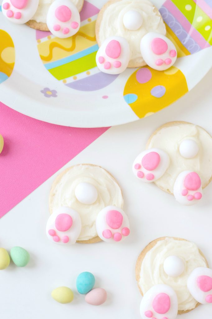 Bunny Bum Cookies on easter paper plate with more bunny bum cookies on pink and white background.
