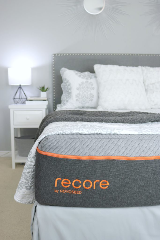 The Recore by Novosbed mattress with blankets folded back to show grey and orange mattress.