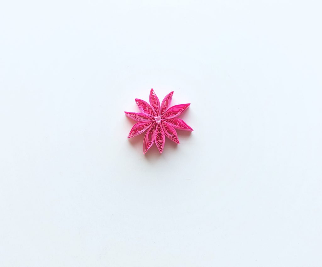 The quilled flower is formed now that all pieces are glued onto the small circle.