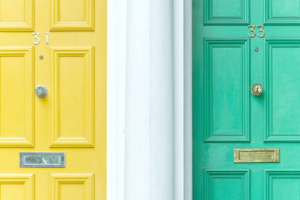 A close up view of a yellow and green door with numbers 31 and 33.