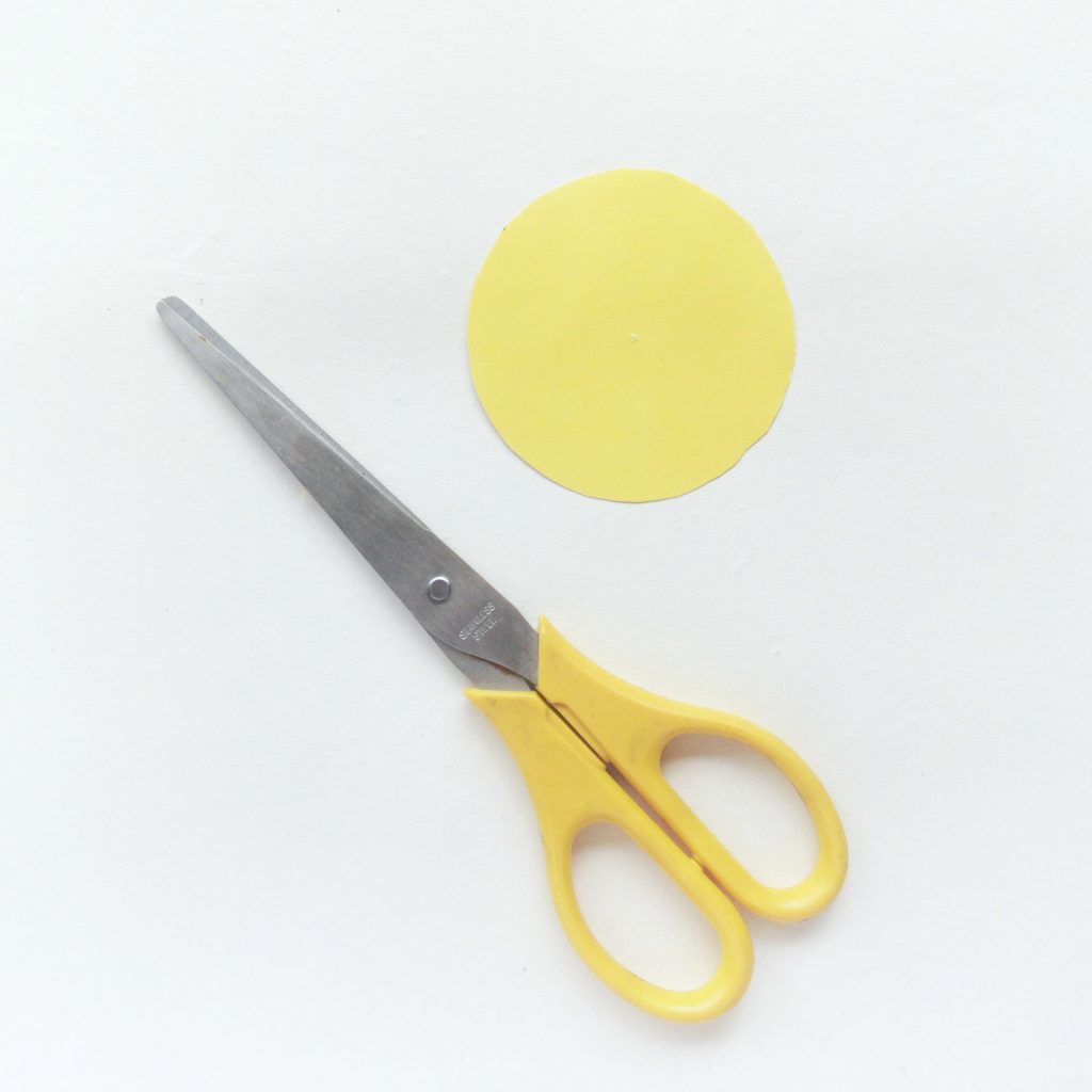 Scissors with yellow circle cut out.