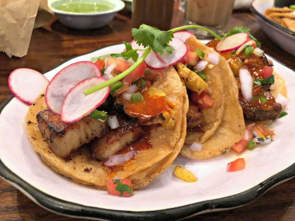 3 tacos filled with pico de gallo, pork belly, beets, and cilantro with grilled pineapple. 