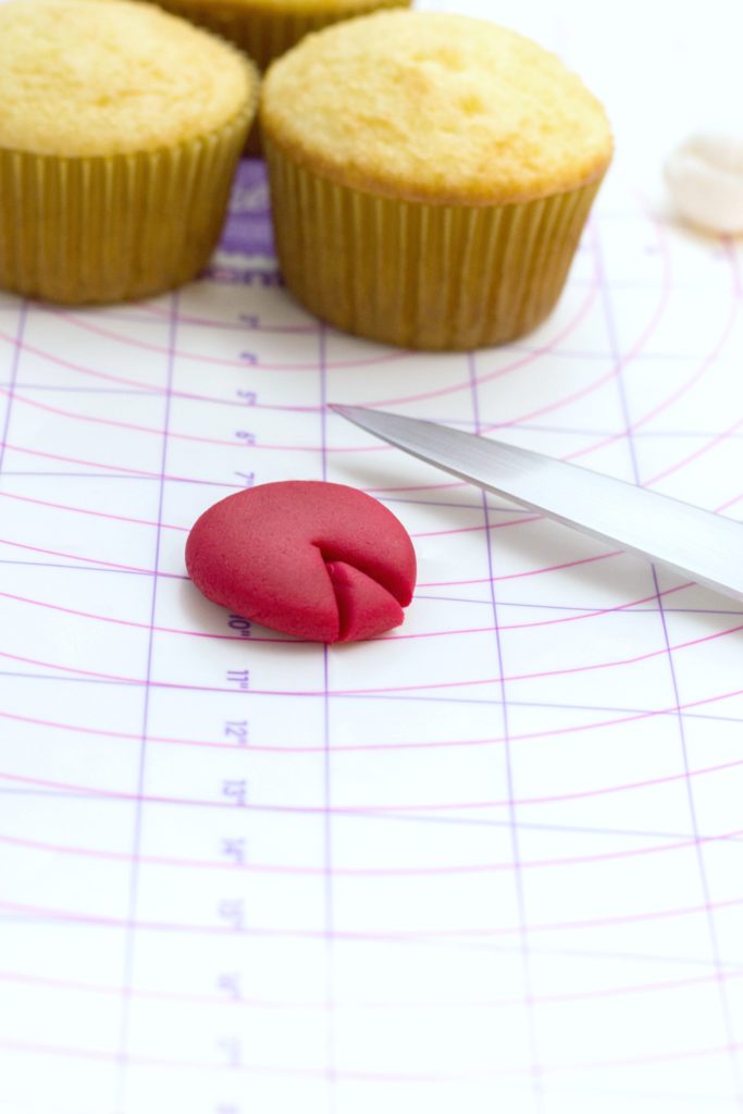Red fondant circle has triangle cut out. 