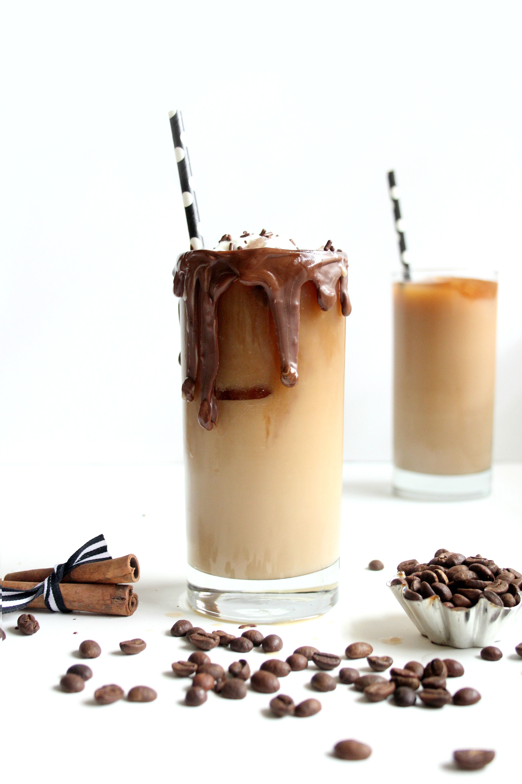 Glass of vanilla iced coffee with chocolate dripping.