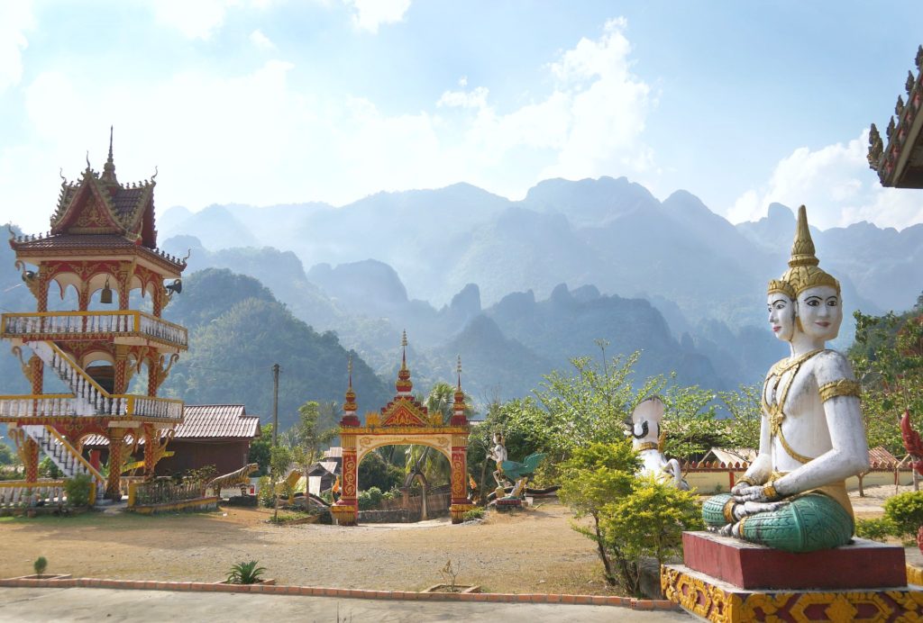 A Laos temple is shown with a Buddha statue. 