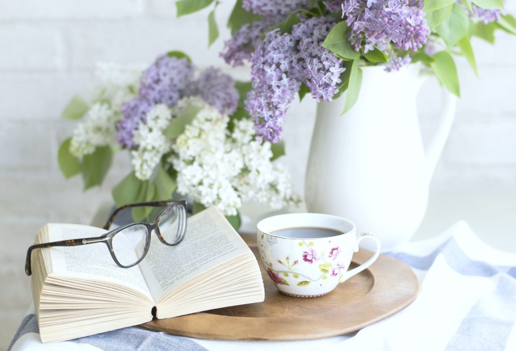Relaxing shot of books, tea, and beautiful flowers. 