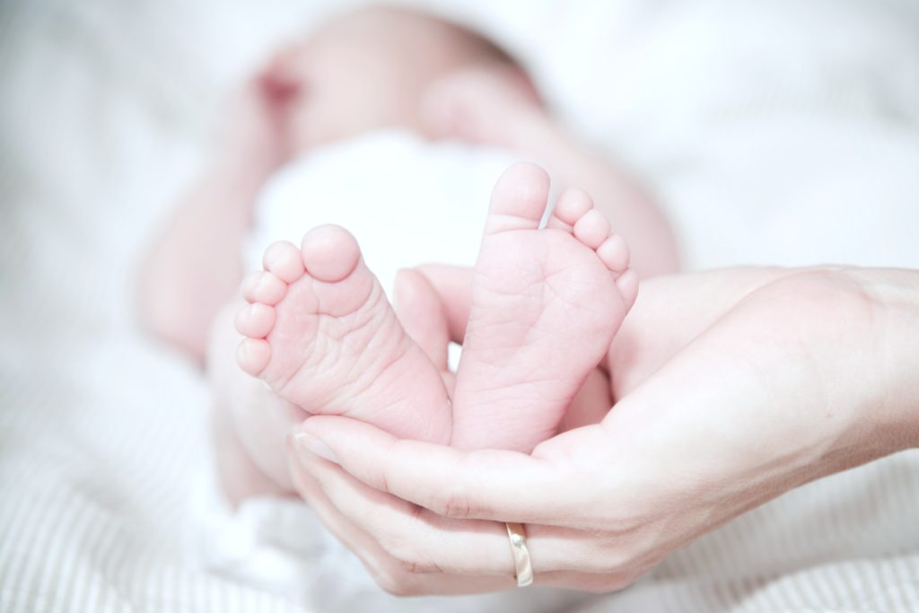 Woman holding baby's feet in her hands.
