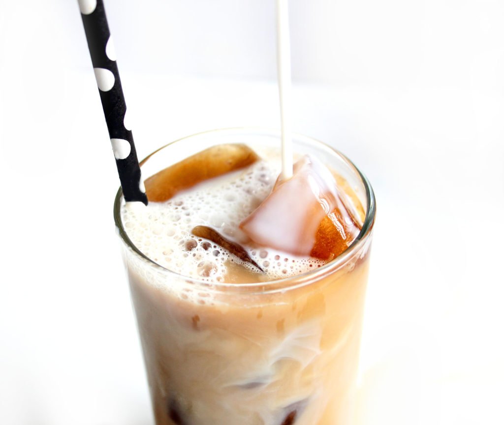 Milk is being poured on coffee ice cubes and iced coffee mix.