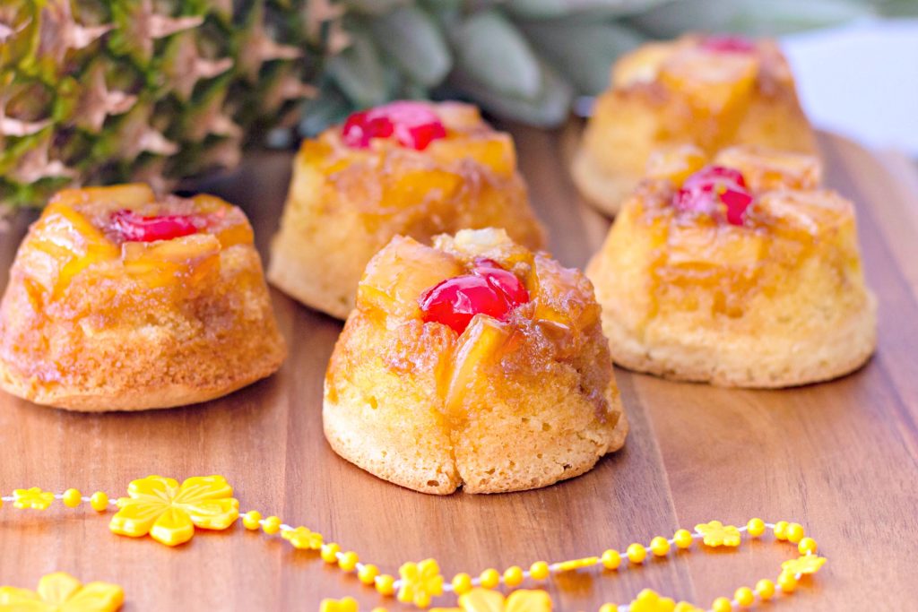 The finished product. Mini upside down pineapple cakes with a small lei and pineapple surrounding them. 