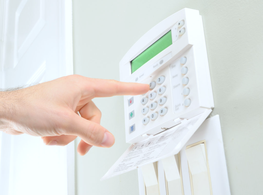 Man activating his alarm system and putting in his code. 