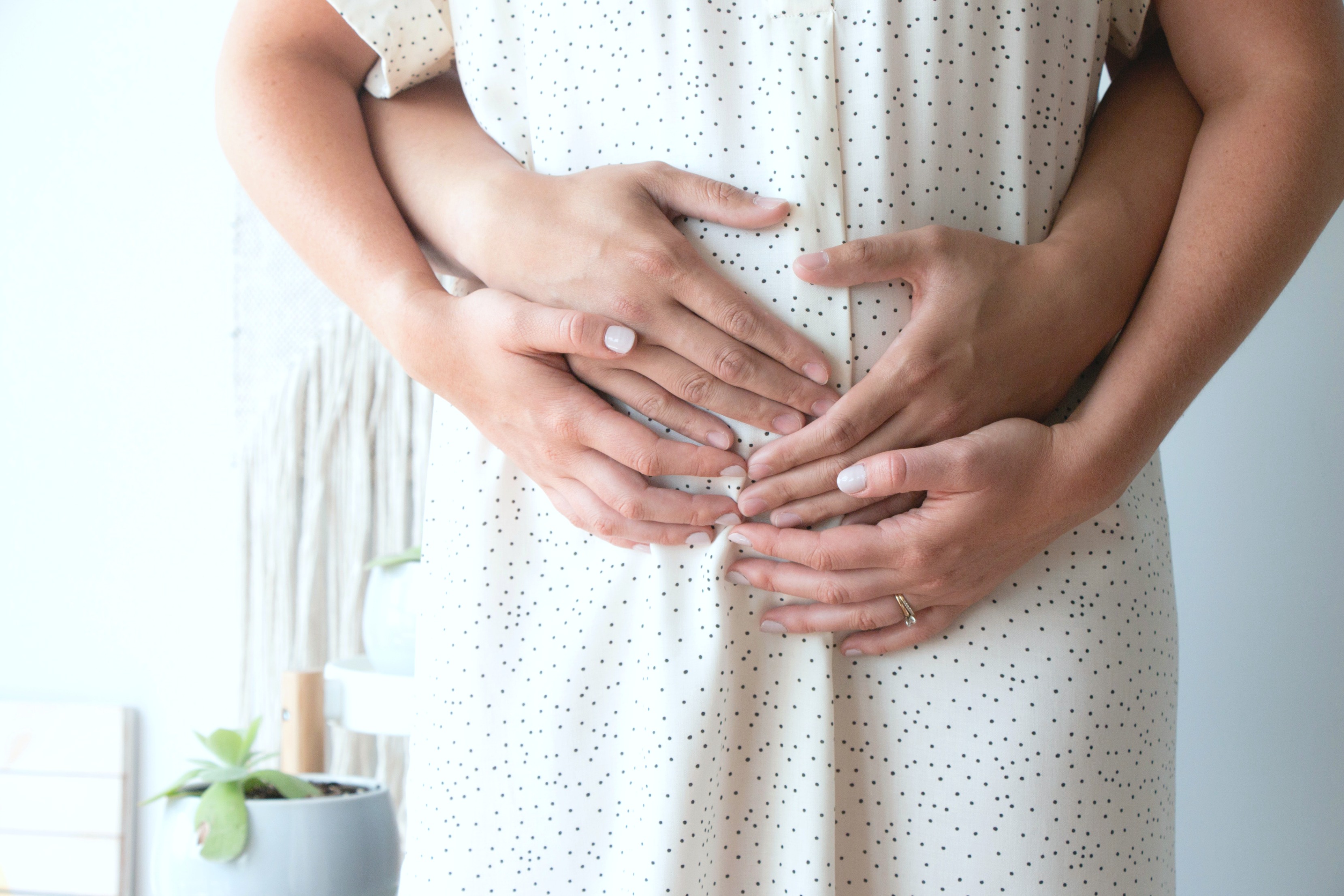 Portrait of a couple holding mother's tummy in anticipation of pregnancy.