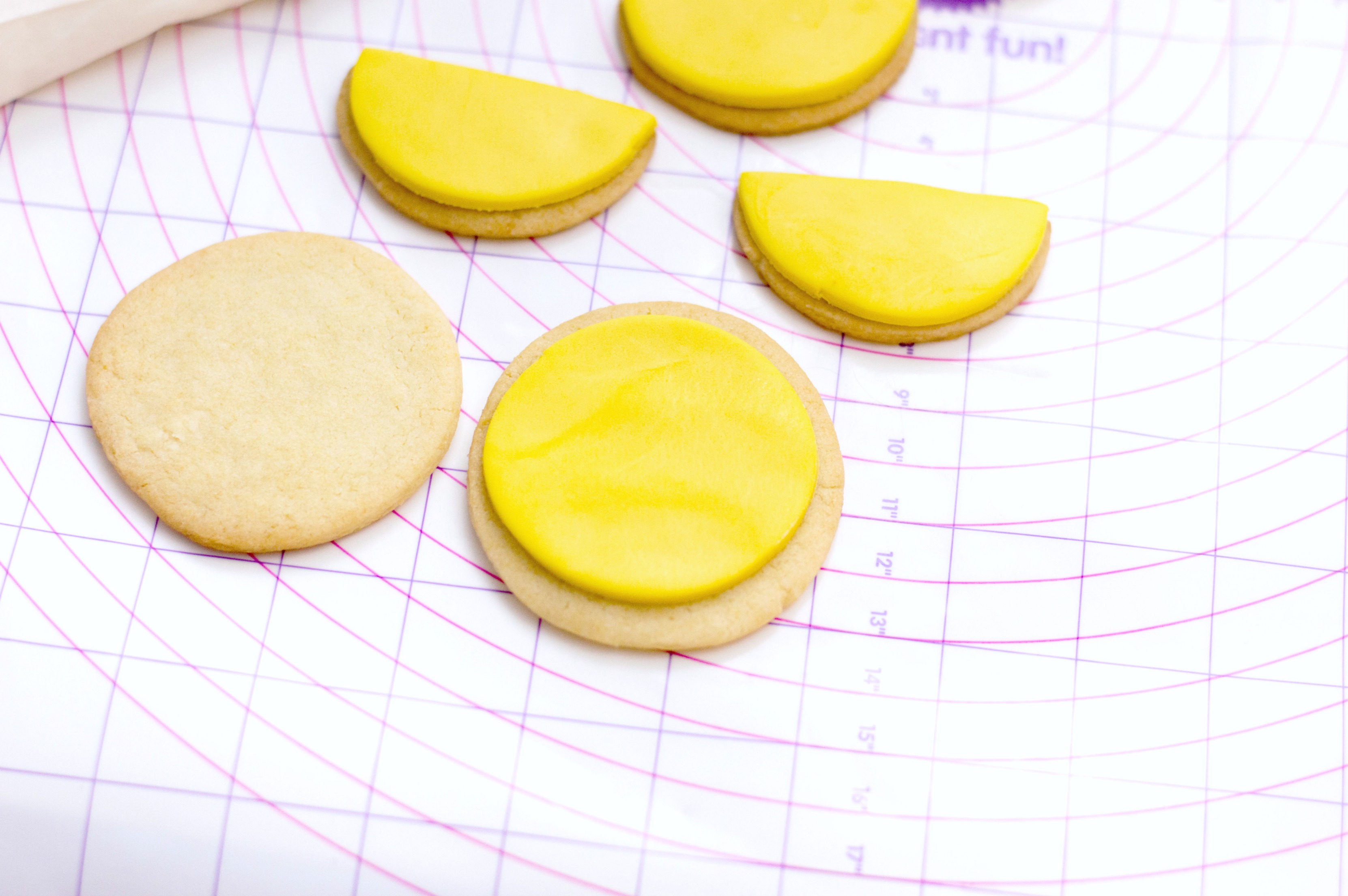 Fondant being placed onto sugar cookies. 