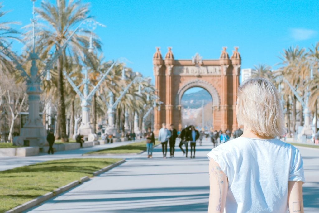 A girl stands and people watches in Barcelona, Spain.