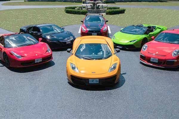 A group of exotic cars are parked facing the camera, as in an invitation to get in and ride. 