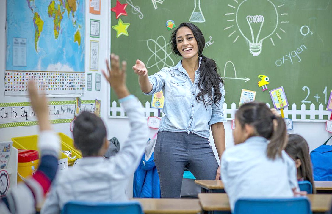 Teacher is pointing to a student to answer a question in class. 