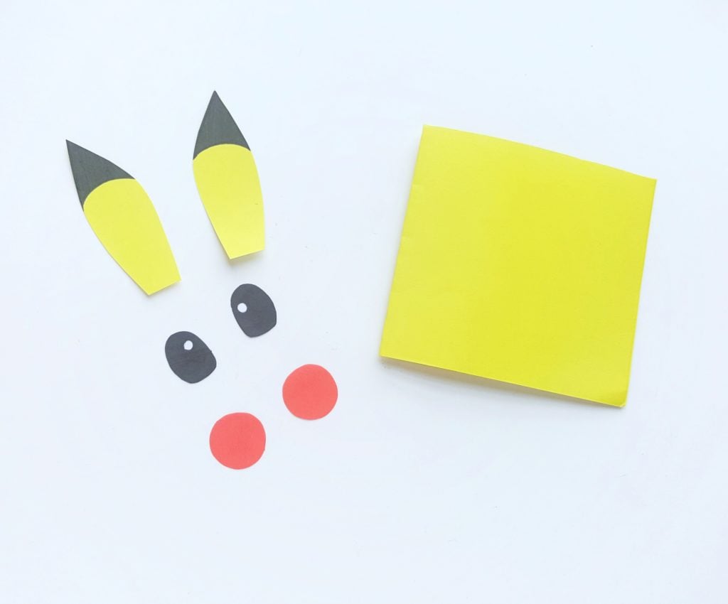 Eyes are coloured black with a yellow speck, ear tips are coloured in as well. The Pokemon Mini Notebook sits next to pieces. 