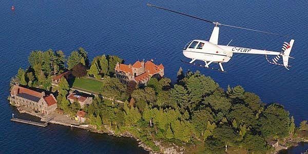 A white helicopter flies over the 1000 islands in Vancouver. Totally the best experiences to give dad.