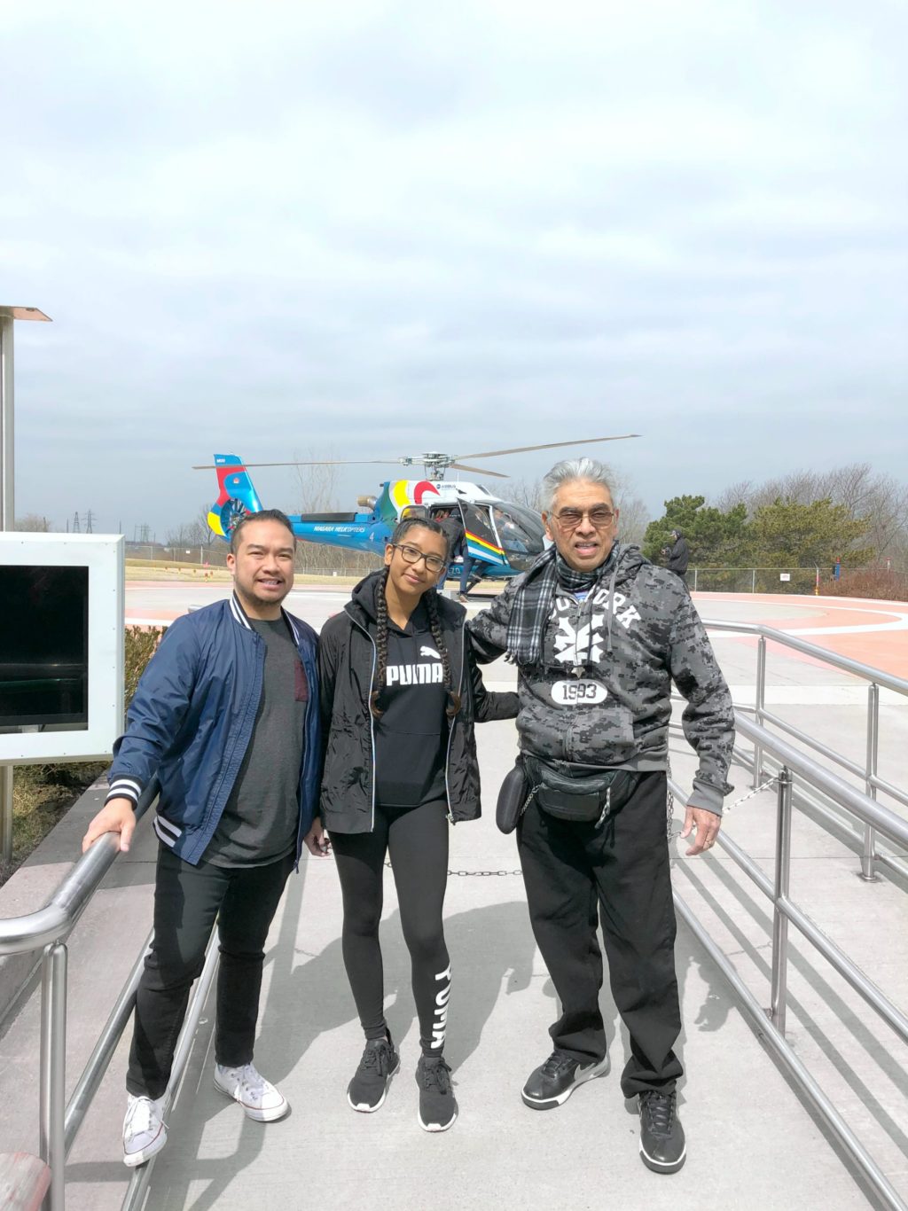 Gabby, Darasak, and Frank Sr. stand in front of the line ready to go on the helicopter. 