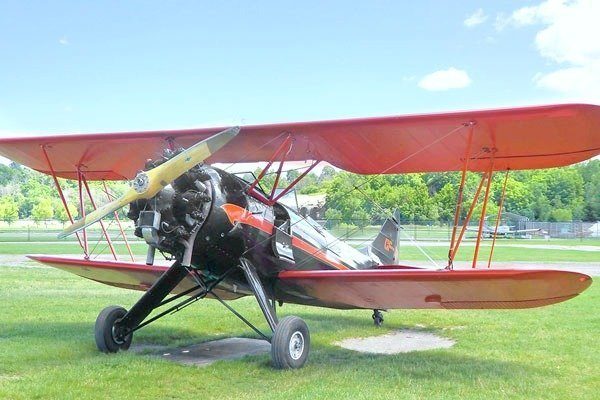 A propeller plane is ready to take off in a field. 