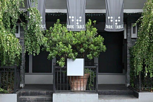 Best experiences to give dad. A restaurant storefront and entrance, fully blacked out windows, the signs read "Dark Table".