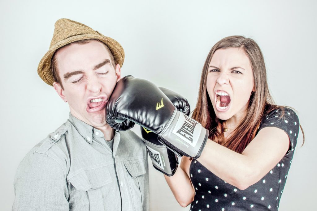 Two teenagers fight, one hits the other with a glove.