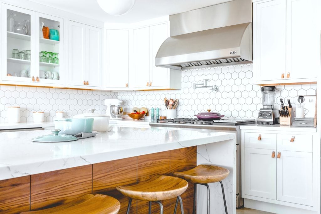 A white and rustic kitchen is mixed with modern touches and warmth from wood.