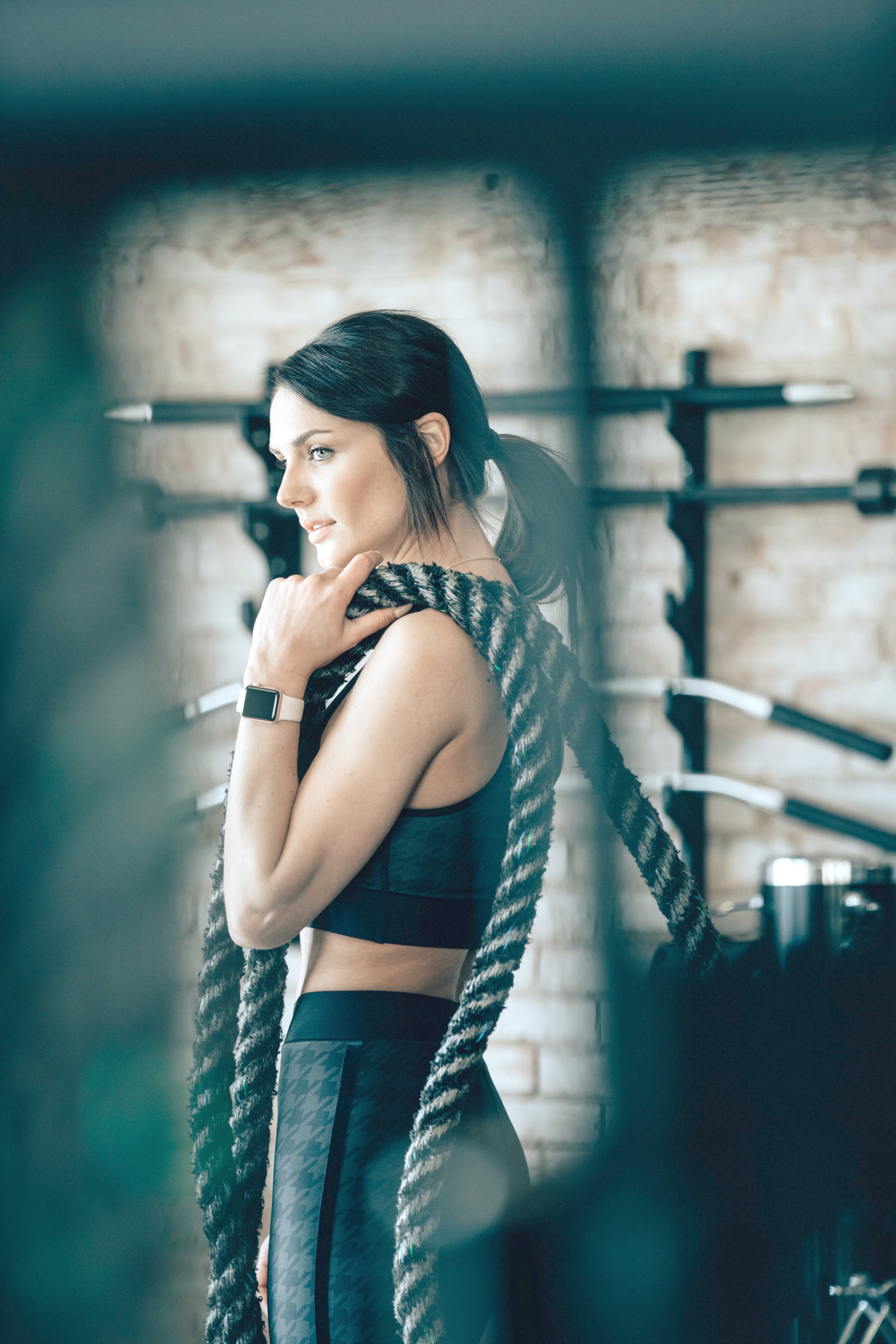 Woman holding battle ropes in her home gym. 