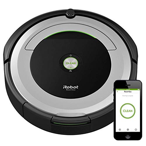 An iRobot Roomba with a phone showing it connected to the vacuum.