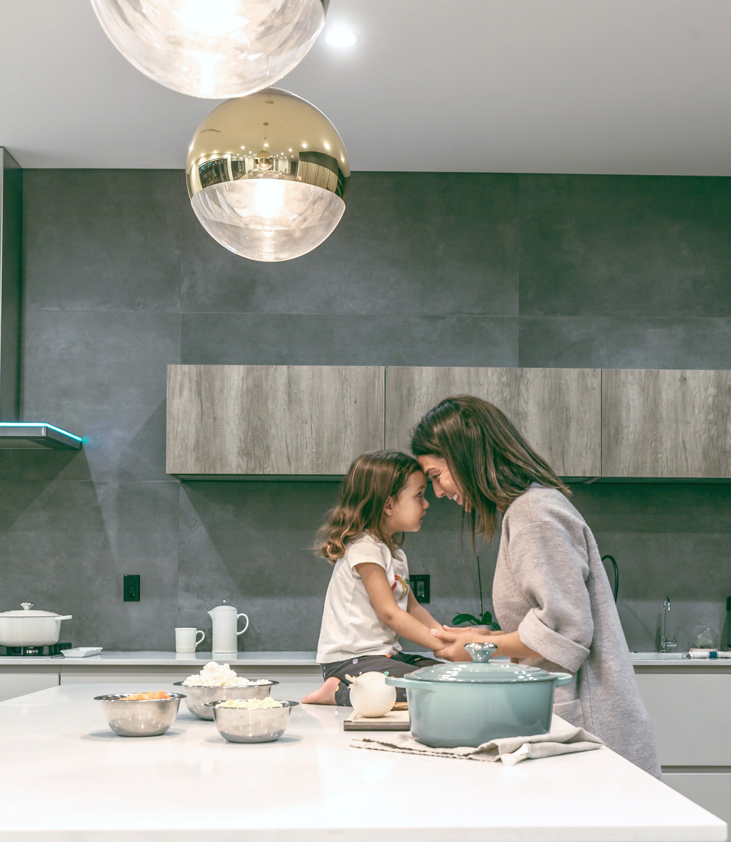 Mother and child in kitchen, touch foreheads, they're very happy. Making your home pretty will help to increase the feel-good factors in your home. 