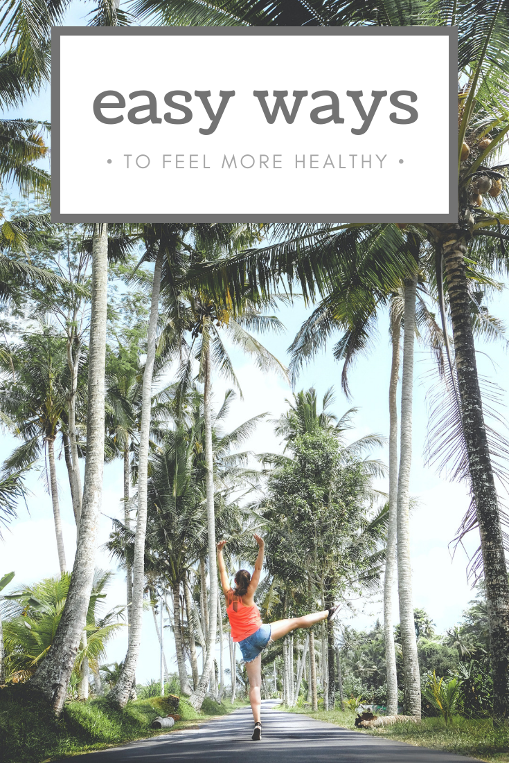 A banner reads, "Easy Ways to Feel Healthier," the whole picture is seen of a two rows of tall palm trees and a woman in the center is jumping in the air. 