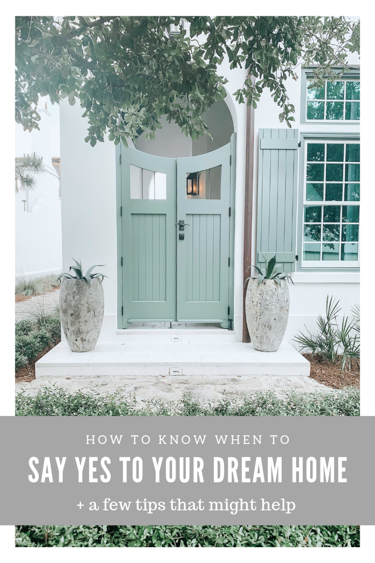 A beautiful white house with a green door, two potted plants are next to the doorway. A banner on top reads, "How to know when to say yes to your dream home + tips that can help."