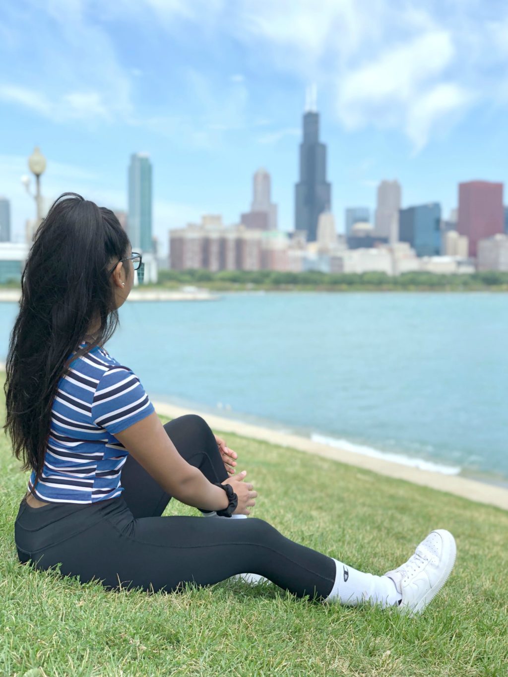 Gabby sitting by Lake Michigan overlooking the Chicago skyline.