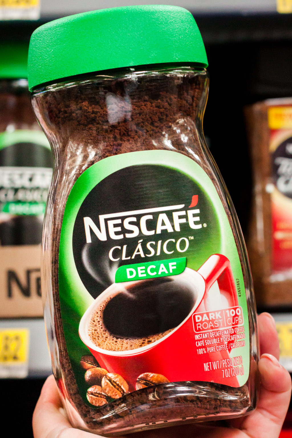 Holding NESCAFE CLASICO in the coffee aisle.