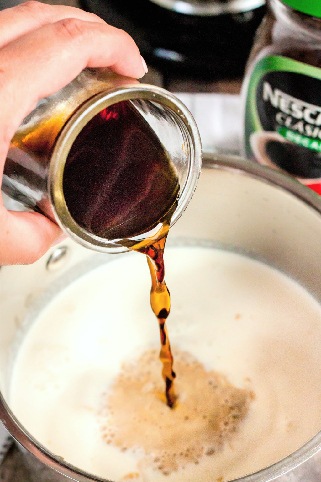 Coffee is poured into the Tres Leches mixture.